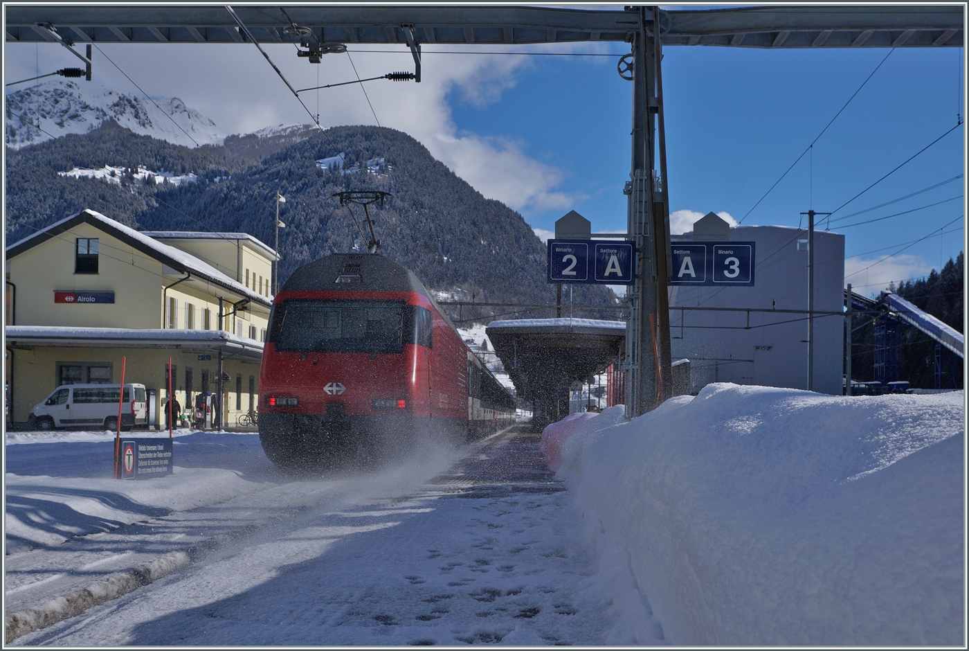 Unverkennbar ein Nachschuss... Schnee auf wirbelnd schieb eine SBB Re 460 nach dem Verlassen des Gotthard Tunnels in Airolo ihren IC 21 10667 in Richtung Lugano. Der Zug verkehrt von Basel SBB nach Lugano.

21. Januar 2025 