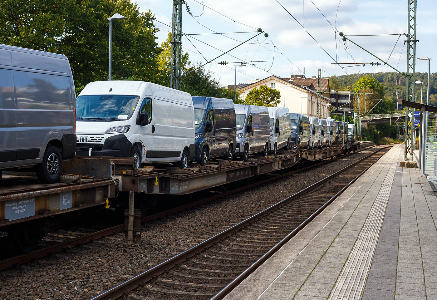 Vierachsige (2 x 2 achsige) Flachwageneinheiten mit abgesenktem Fu�boden und Radvorlegern 23 83 4308 226-5 I-GAAL, der Gattung Laaps (TWA 1065/FST), der GAAL S.p.a. (Moncalieri/Italien), beladen mit 4 FIAT Nutzfahrzeuge, am 15 September 2024 im Zugverband bei einer Zugdurchfahrt im Bahnhof Kirchen (Sieg).

TECHNISCHE DATEN:
Gattung: Laaps (TWA 1065/FST)
Spurweite: 1.435 mm (Normalspur)
Anzahl der Achsen: 4
L�nge �ber Puffer : 27.000 mm
Achsabst�nde: 8.780 mm / 3.940 mm / 8.780 mm
Ladel�nge : 25.630 mm
Ladel�nge abgesenkte Bereich: 19.140 mm (bzw. 2 x 9.250 mm)
Ladebreite : 3.085 mm
Anzahl Radvorleger: 2 x 12 = 24
Ladefl�che: 77 m�
Fu�bodenh�he �ber SOK: 1.065 mm (abgesenkte Bereich)
H�chstgeschwindigkeit: 100 km/h
Eigengewicht: 27.000 kg
Nutzlast: 51,0 t ab Streckenklasse C
Kleinster befahrb. Gleisbogenhalbmesser: 70 m
Bremse: Freno WU-GP (LL)
Bremssohle: C952-1
Handbremse: Nein
Intern. Verwendungsf�higkeit: RIV
