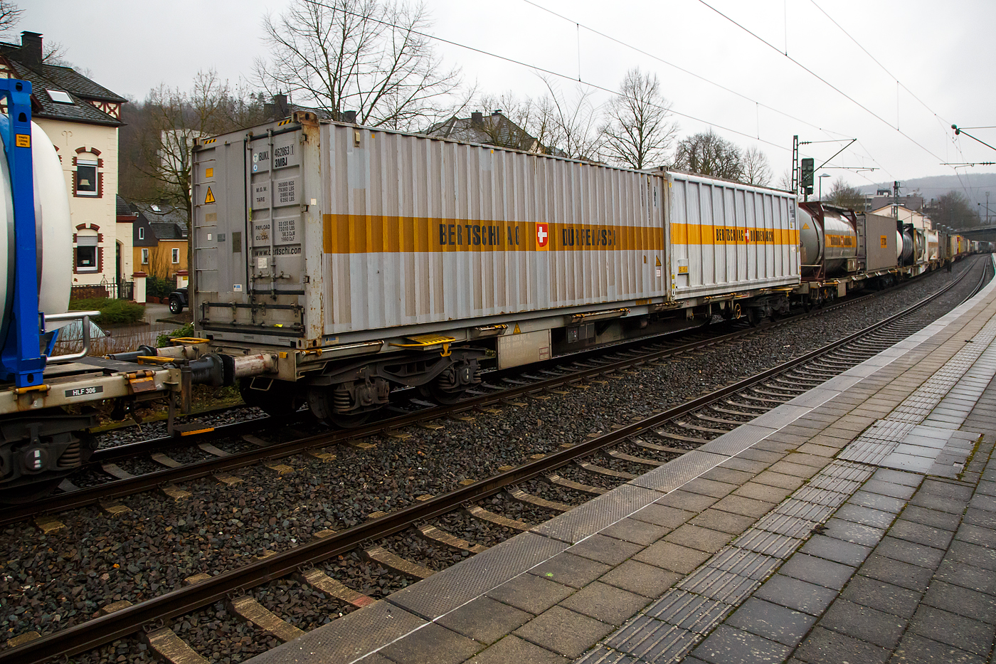 Vierachsiger Drehgestell-Containertragwagen der Gattung Sgnss, 33 85 4575 627-6 CH-HUPAC, der HUPAC Intermodal SA am 31.01.2023 im Zugverband bei der Durchfahrt in Kirchen (Sieg). Hier beladen mit zwei ISO-Containern vom Logistikdienstleister Bertschi AG (Dürrenäsch / Schweiz).

Der Wagen wurde 2003 von Josef Meyer Rheinfelden (CH) gebaut.

TECHNISCHE DATEN:
Hersteller: Josef Meyer Rheinfelden
Spurweite: 1.435 mm
Länge über Puffer: 20.050 mm
Drehzapfenabstand: 14.420 mm
Achsabstand in den Drehgestellen: 1.800 mm
Laufraddurchmesser: 920 mm (neu)
Ladelänge: 18.760 mm
Eigengewicht: 20.000 kg
Max. Zuladung bei Lastgrenze S: 70,0 t (ab Streckenklasse D)
Max. Zuladung bei Lastgrenze SS: 39,0 t (ab Streckenklasse A)
Max. Geschwindigkeit: 100 km/h, bei Lastgrenze SS oder leer 120 km/h
Kleinster befahrbarer Gleisbogen: R 75 m 
Verwendungsfähigkeit: RIV