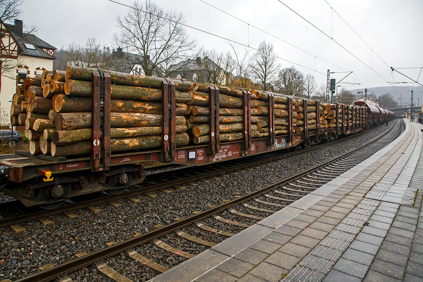 Vierachsiger Drehgestell-Flachwagen Doppelrungen und Niederbindeeinrichtung, 31 80 4723 423-2 D-DBSNI, der Gattung Snps 719 der DB Cargo Logistics GmbH (ex DB Schenker Nieten GmbH), beladen mit Buchen-Rundholz am 31.01.2023 im Zugverband bei der Durchfahrt in Kirchen (Sieg).

Diese Drehgestell-Flachwagen wurde speziell für den Transport von Rohren, Profilstahl, Flachstahlprodukten, sowie Stamm- und Schnittholz entwickelt und zeichnet sich durch hohe Ladekapazität und optimierte Ladesicherung aus. Sie wurden ab 1980 als Sps 719 beschafft und ab 1988 in Snps 719 umgezeichnet.

Zur Aufnahme und Abstützung der Ladung sind auf dem Wagenboden Ladeschwellen und an den Wagenlängsseiten Rungen angebracht. Zur Verzurrung der Ladung sind von Hand zu bedienende Niederbindeeinrichtungen vorhanden. Für die Auflage des Ladegutes sind hölzerne Ladeschwellen im Rungenbereich und im Abstand von 1 m von Wagenende vorhanden. Außerdem sind feste 5 mm niedrigere Hilfsladeschwellen zwischen den Rungen zur Unterstützung von leicht durchhängendem Ladegut (z. B. Schnittholz) angeordnet. Die Ladeschwellen sind genügend hoch, so dass die handelsüblichen Umschlagmittel verwendet werden können. Der Wagenboden ist mit einem begehbaren Loch- bzw. Riffelblech vollständig abgedeckt. Zur Aufnahme von Lasten oder zum Befahren mit Flurförderfahrzeugen sind die Abdeckungen nicht geeignet. Zur Sicherung der Ladung sind auf jeder Wagenlängsseite in gleichmäßigen Abständen 8 Rungen vorhanden. Die Rungen sind mit dem Untergestell-Außenlangträger fest verbunden und so ausgeführt, dass sie die durch die Ladung entstehenden Kräfte in Wagenlängs- und Wagenquerrichtung sicher aufnehmen können. Die Innenseiten der Rungen sind ausgekleidet.

Zur Verzurrung des Ladegutes ist jedes Rungenpaar mit einer Niederbindeeinrichtung ausgerüstet, die von einer Person bedient werden kann. Die Spanngurte sind zur Schonung des Ladegutes mit einem elastischen Werkstoff ummantelt. Die Länge des Gurtes und die Teilung der Raster sind so gewählt, dass auch Ladungen, die nur etwa die halbe Rungenhöhe einnehmen, verzurrt werden können.

TECHNISCHE DATEN:
Gattung: Snps 719
Spurweite: 1.435 mm (Normalspur)
Länge über Puffer: 20.840 mm
Drehzapfenabstand: 15.800 mm
Radsatzstand in den Drehgestellen: 1.800 mm
Ladelänge: 19.000 mm
Ladebreite: 2.723 mm (zwischen den Rungen)
Fußbodenhöhe über SO: 1.280 mm (OK Ladeschwelle)
Rungenhöhe: 2.000 mm
Eigengewicht: 24.400 kg
Zuladung bei Lastgrenze S: 63 t (ab Streckenklasse D)
Max. Geschwindigkeit: 100 km/h / 120 km/h (leer)
Kleinster Gleisbogenhalbmesser: 35 m
Bauart der Bremse: KE-GP (LL)
Bremssohle: IP 116
Verwendungsfähigkeit: RIV