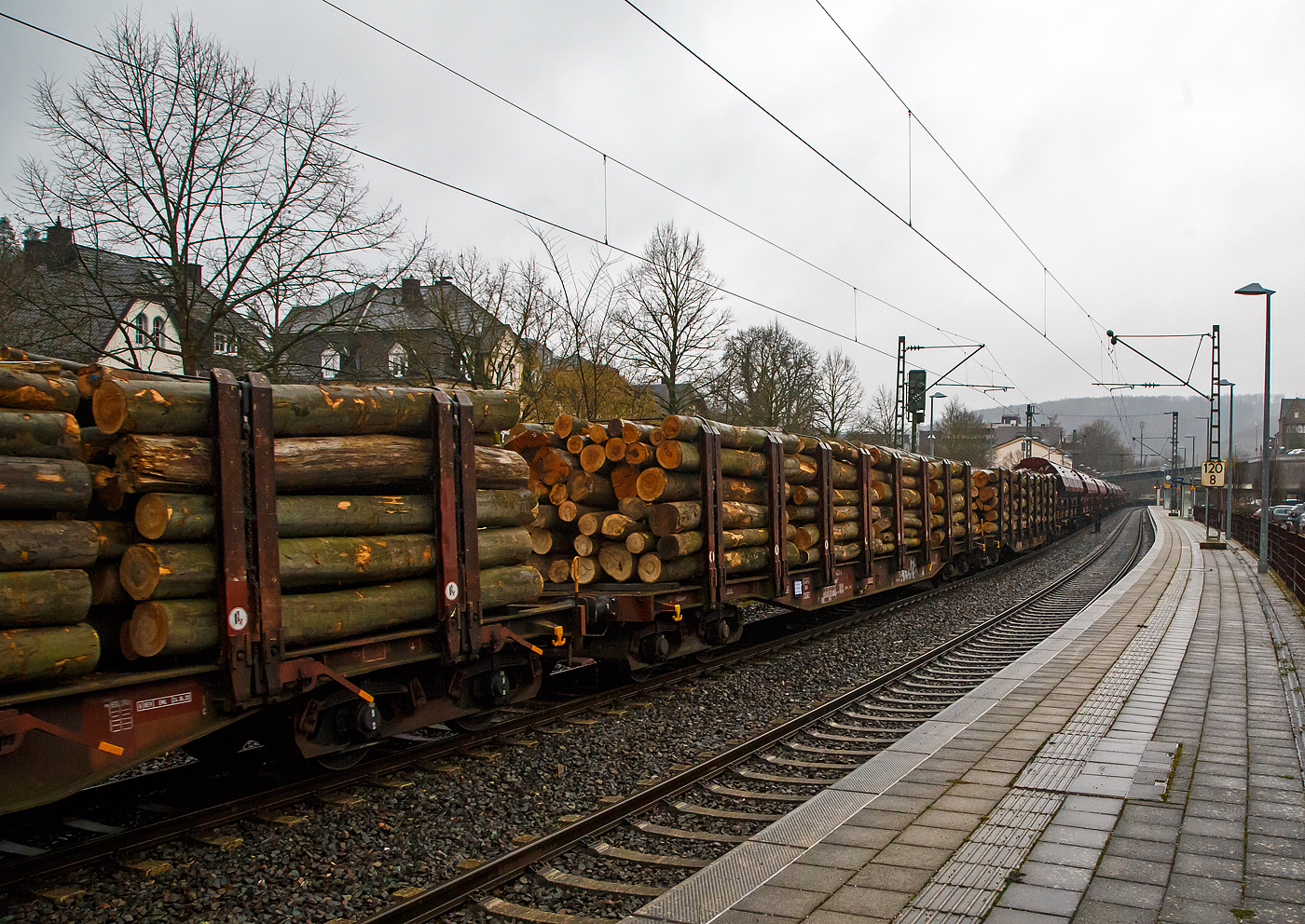 Vierachsiger Drehgestell-Flachwagen Doppelrungen und Niederbindeeinrichtung, 31 80 4723 423-2 D-DBSNI, der Gattung Snps 719 der DB Cargo Logistics GmbH (ex DB Schenker Nieten GmbH), beladen mit Buchen-Rundholz am 31.01.2023 im Zugverband bei der Durchfahrt in Kirchen (Sieg).

Diese Drehgestell-Flachwagen wurde speziell für den Transport von Rohren, Profilstahl, Flachstahlprodukten, sowie Stamm- und Schnittholz entwickelt und zeichnet sich durch hohe Ladekapazität und optimierte Ladesicherung aus. Sie wurden ab 1980 als Sps 719 beschafft und ab 1988 in Snps 719 umgezeichnet.

Zur Aufnahme und Abstützung der Ladung sind auf dem Wagenboden Ladeschwellen und an den Wagenlängsseiten Rungen angebracht. Zur Verzurrung der Ladung sind von Hand zu bedienende Niederbindeeinrichtungen vorhanden. Für die Auflage des Ladegutes sind hölzerne Ladeschwellen im Rungenbereich und im Abstand von 1 m von Wagenende vorhanden. Außerdem sind feste 5 mm niedrigere Hilfsladeschwellen zwischen den Rungen zur Unterstützung von leicht durchhängendem Ladegut (z. B. Schnittholz) angeordnet. Die Ladeschwellen sind genügend hoch, so dass die handelsüblichen Umschlagmittel verwendet werden können. Der Wagenboden ist mit einem begehbaren Loch- bzw. Riffelblech vollständig abgedeckt. Zur Aufnahme von Lasten oder zum Befahren mit Flurförderfahrzeugen sind die Abdeckungen nicht geeignet. Zur Sicherung der Ladung sind auf jeder Wagenlängsseite in gleichmäßigen Abständen 8 Rungen vorhanden. Die Rungen sind mit dem Untergestell-Außenlangträger fest verbunden und so ausgeführt, dass sie die durch die Ladung entstehenden Kräfte in Wagenlängs- und Wagenquerrichtung sicher aufnehmen können. Die Innenseiten der Rungen sind ausgekleidet.

Zur Verzurrung des Ladegutes ist jedes Rungenpaar mit einer Niederbindeeinrichtung ausgerüstet, die von einer Person bedient werden kann. Die Spanngurte sind zur Schonung des Ladegutes mit einem elastischen Werkstoff ummantelt. Die Länge des Gurtes und die Teilung der Raster sind so gewählt, dass auch Ladungen, die nur etwa die halbe Rungenhöhe einnehmen, verzurrt werden können.

TECHNISCHE DATEN:
Gattung: Snps 719
Spurweite: 1.435 mm (Normalspur)
Länge über Puffer: 20.840 mm
Drehzapfenabstand: 15.800 mm
Radsatzstand in den Drehgestellen: 1.800 mm
Ladelänge: 19.000 mm
Ladebreite: 2.723 mm (zwischen den Rungen)
Fußbodenhöhe über SO: 1.280 mm (OK Ladeschwelle)
Rungenhöhe: 2.000 mm
Eigengewicht: 24.400 kg
Zuladung bei Lastgrenze S: 63 t (ab Streckenklasse D)
Max. Geschwindigkeit: 100 km/h / 120 km/h (leer)
Kleinster Gleisbogenhalbmesser: 35 m
Bauart der Bremse: KE-GP (LL)
Bremssohle: IP 116
Verwendungsfähigkeit: RIV