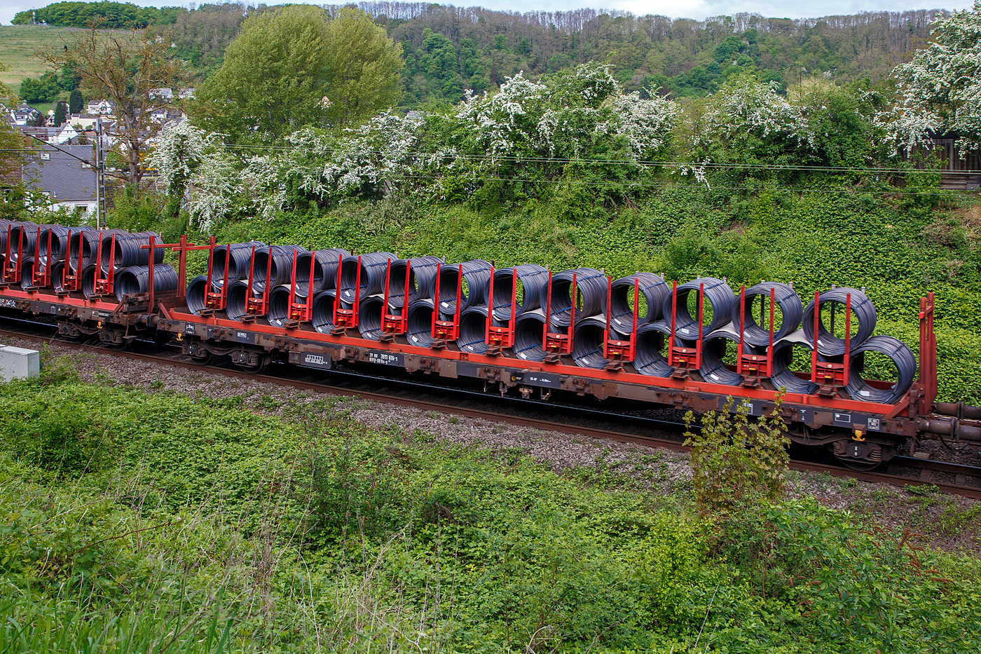 Vierachsiger Drehgestell-Flachwagen mit speziellem Ladegestell f�r Drahtrollen, 31 80 3911 616-1 D-DB der Gattung Rs-y 667, der DB Cargo Deutschland AG, am 28.02.2018 im Zugverband bei einer Zugdurchfahrt durch Koblenz-Moselwei�, hier beladen mit Stahldrahtrollen.

Die zur Aufarbeitung nach 25 Jahren Einsatzzeit anstehenden Res 687 standen auch f�r den Umbau zu Rs-y 667 bereit. Die Wagen sind bereits seit Beginn ihres Einsatzes unter anderem f�r den Transport von Drahtrollen im Einsatz. Einerseits um den Ladevorgang zu optimieren und andererseits die Ladungssicherung zu erh�hen, sind mehrere Versuche mit Gestellen f�r Stahldrahtrollen durchgef�hrt worden. Zuerst wird im Jahre 2003 im DB Werk Paderborn ein Schiebeplanen-Wagen der Gattung Rilns 654 mit solchen Gestellen zu einem Ril(n)s-y 649 umger�stet, 2004 entsteht der Rs-y 667 durch Umbau aus Res 687, ebenfalls in Paderborn. Es ist eine Serie von 300 Wagen geplant. Die Bordw�nde und Drehrungen werden entfernt, hohe Stirnrungen und ein Ladegestell mit 12 verschiebbaren Doppelrungenpaaren werden als ein festes Element auf dem Wagenboden verankert. Das zul�ssige Zuladungsgewicht vermindert sich dadurch um etwa 3 Tonnen.

Die Ladegestelle verf�gen �ber jeweils13 holzverkleidete Mulden, die die untere Lage der Drahtrollen aufnehmen. Weitere 12 Rollen k�nnen gesattelt auf der ersten Lage verladen werden. In Querrichtung wird die Ladung durch12 individuell von Hand verschiebbare Doppelrungenpaare gesichert. Die Drahtrollen k�nnen einen Au�en-�  bis zu 1,25 m und eine Breite bis zu 2,0 m  besitzen.

TECHNISCHE DATEN:
Spurweite: 1.435 mm (Normalspur)
Anzahl der Achsen: 4 in 2 Drehgestellen
L�nge �ber Puffer: 19.900 mm
Drehzapfenabstand: 14.860 mm
Achsabstand in den Drehgestellen: 1.800 mm
Eigengewicht: 26.820 kg
H�he Fu�boden: 1.238mm
Maximale Ladegewicht: 53 t (ab Streckenklasse C)
H�chstgeschwindigkeit: 100 km/h 
Kleinster befahrbarer Gleisbogenhalbmesser: R 35 m
Bremse: KE-GP (LL)
Bremssohle: IB 116
Intern. Verwendungsf�higkeit:  RIV
