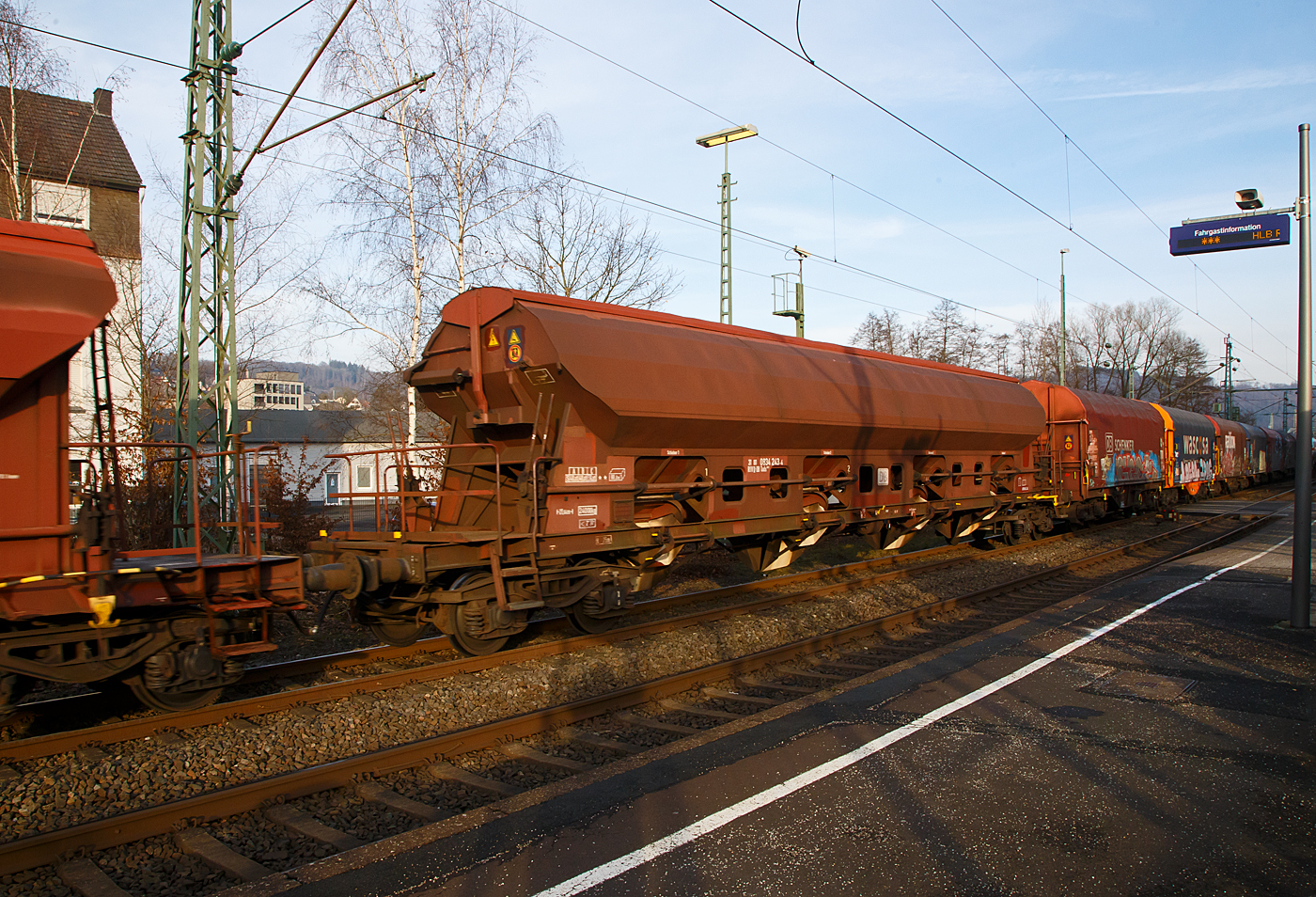 Vierachsiger gedeckter Drehgestell-Schüttgutwagen mit dosierbarer Schwerkraftentladung, 31 80 0834 243-4 D-DB, der Gattung Tads 960, der DB Cargo AG am 18.01.2023 im Zugverband bei einer Zugdurchfahrt in Scheuerfeld (Sieg).

Die Wagen sind geeignet für den Transport von witterungsempfindlichen Schüttgütern. Die Ladegüter sind z.B. Quarzsand, Dolomit, Anthrazit, Gipsstein, Kalk, Holzpellets, Petrolkoks, Kaolin und Paraffine. Die Beladung erfolgt über ein einteiliges Schwenkdach. Sie besitzen eine gleisseitige dosierbare Entladeeinrichtung. Ein Teil der Wagen ist für den Transport von Quarzsand mit speziellen Dichtungen an den Auslaufrutschen ausgestattet.

Die Wagen der Bauart Tads 960 sind durch Umzeichnung aus der Bauart Tads 959 hervorgegangen. Der Wagen dient wegen seiner besonderen Schieberabdichtung dem Transport von feinkörnigen, nässeempfindlichen Schüttgütern, besonders für Quarzsand. Der Transport grobkörniger oder kantiger, schwerer Güter (z. B. Kies, Schlacke, Schotter) ist wegen einer möglichen Beschädigung der Innenbeschichtung nicht zulässig. Der Wagen kann wahlweise nach der einen oder anderen Seite oder gleichzeitig nach beiden Seiten entladen werden. Die regelbare Entladung ermöglicht die Beschickung von Förderbändern. Die schwenkbaren Auslaufrutschen gestatten den Einsatz des Wagens für die Entladung in Bunkern oder auf seitliche Förderbänder.

Das Untergestell ist aus Walzprofilen (St 52-3) geschweißt. Der Wagenkasten ist ebenfalls geschweißt. Für die 3 mm dicken Kastenbleche wurde St 52-3 mit Cu-Zusatz verwendet. In jeder Seitenwand sind vier exzentrisch gelagerte Rundschieber angeordnet. Jeder Schieber kann einzeln mit einem Handhebel von der Bühne aus geöffnet und geschlossen werden.Die Unterkanten der festen Auslaufrutschen liegen bei leerem Wagen 720 mm über SO. Die Unterkanten der beweglichen Auslaufrutschen liegen bei leerem Wagen im ausgeschwenkten Zustand 385 mm über SO.

Zum Beladen des Wagens wird das Schwenkdach von der Bedienungsplattform aus mit einem Handrad geöffnet. Dabei wird eine über die ganze Wagenlänge reichende Öffnung von 1 200 mm Breite freigegeben. Das geöffnete Dach bleibt innerhalb der Wagenbegrenzungslinie, so dass Verschiebebewegungen auch bei geöffnetem Schwenkdach möglich sind.

Das Entfernen von Ladegutresten in der Be- oder Entladestraße ist nur durch leichte Gummihammerschläge auf die äußeren Behälterwandungen gestattet oder durch den Einsatz von Pressluftlanzen im Laderaum.

TECHNISCHE DATEN:
Hersteller: Waggonfabrik Talbot in Aachen
Baujahr: ab 1973 (Umzeichnung 2003 – 2006)
Spurweite: 1.435 mm
Länge über Puffer : 21.640 mm
Drehzapfenabstand: 16.600 mm
Achsabstand im Drehgestell: 1.800 mm
Beladeöffnung: 16.800 x 1.200 mm
Eigengewicht: 24.000 kg
Höchstgeschwindigkeit:  100  km/h (beladen) / 120 km/h (leer)
Maximales Ladegewicht: 56,0 t (Streckenklasse C oder höher)
Kleinster bef. Gleisbogenradius: 75 m
Rauminhalt: 80,0 m³
Bremse: KE-GP-A 
Intern. Verwendungsfähigkeit: RIV

Die Bedeutung der Gattungs- und Kennbuchstaben (hier Tads):
T - Wagen mit öffnungsfähigem Dach 
a - mit vier Radsätzen
d - mit Schwerkraftentladung, dosierbar, wahlweise zweiseitig, hochliegend
s - Höchstgeschwindigkeit 100 km/h (beladen)