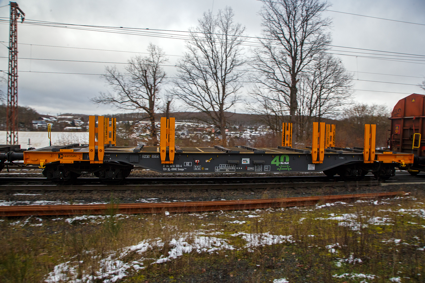 Vierachsiger leerer Drehgestell-Flachwagen mit Doppelrungen, 37 84 4616 533-4 NL-ORME, der Gattung Smnps, Bauart 193-4, der On Rail Gesellschaft f�r Eisenbahnausr�stung und Zubeh�r mbH (Mettmann), vermietet an Saarstahl AG, am 27.01.2023 im Zugverband bei der Durchfahrt in Rudersdorf (Kr. Siegen). Nach dem Aufkleber (MFI) zu urteilen geh�ren die MFI - Mat�riel Ferroviaire et Industriel S.A. und die On Rail wohl nun zusammen.

Diese Wagen wurden vom bulgarischen Hersteller Transwagon AD in Burgas gebaut.

Der Wagen hat einen durch Gitterroste begehbaren Fu�boden Gitterroste, Hartholz-Ladeschwellen, Niederbindeeinrichtungen (Gut-Spanneinrichtungen), Rungen mit auswechselbaren Kunststoffleisten an den Ber�hrungsfl�chen zum Ladegut. Hier bei der Bauart 193-4 haben die Wagen ja L�ngsseite vier sehr steife Doppelrungen (aus HEB-Stahltr�gern), anstatt acht bei der Bauart 193. Zudem sind die Rungen nur ca. halb so hoch, anstatt 2.000 mm bei Bauart 193. Anschraubfl�chen f�r weiter vier Doppel-Rungen sind jedoch vorhanden.

TECHNISCHE DATEN:
Spurweite: 1.435 mm (Normalspur)
L�nge �ber Puffer: 16.750 mm
Drehzapfenabstand: 11.700 mm
Achsabstand im Drehgestellen: 1.800 mm 
Raddurchmesser: 920 mm (neu)
Drehgestell-Typ: Y25 Lsd
Ladel�nge: 15.500 mm
Ladebreite: 2.830 mm (zwischen den Rungen)
Ladefl�che: 43,8 m�
Eigengewicht: 21.000 kg
Max. Zuladung bei Lastgrenze: 69,0 t (ab Streckenklasse D)
Max. Geschwindigkeit: 100 km/h (beladen) / 120 km/h (leer)
Kleinster Gleisbogenhalbmesser: 45 m
Bauart der Bremse: KE-GP-A (K) max. 58 t
Bremssohle: Cosid C 810
Internationale Verwendungsf�higkeit: TEN-GE
