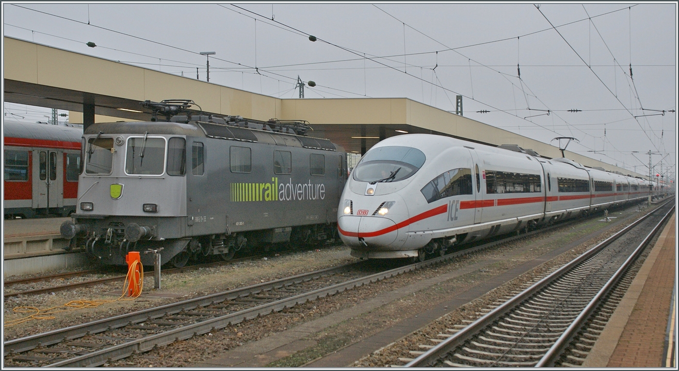 Während ein DB ICE 3 den Bahnhof Basel Bad. Bf in Richtung Deutschland verlässt, wartet die an RailAdenture vermietetet SBB Re 421 383 auf einen neuen Einsatz. 

6. Nov. 2011 