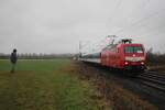 Am verregneten 12 Februar 2026 schiebt TRI 145 097 der RB 37 nach Krefeld Hbf durch Kaarst-Broicherseite und wird vom offenbarer Weg fotografiert. Dieser Himbeerroter Farbgebung ist eine kleiner Witz von TRI; die DB 145er haben diese Farben nie getragen.