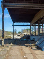 Die letzten Reste der Bremsbahn der Eiserfelder Steinwerke AG des Basaltbruches Mahlscheid (Mahlscheiderkopf). Die ehemalige Verladestation am 24.03.2011 (im gleichen Jahr angerissen) bei der alten Ziegelei in Herdorf.

Der ehemalige Steinbruch Mahlscheid (heute NSG) befindet sich im Westerwald an der Landesgrenze der Bundesländer Rheinland-Pfalz und Nordrhein-Westfalen im Bereich der Gemeinden Herdorf (Landkreis Altenkirchen) und Struthütten (Landkreis Siegen-Wittgenstein). Mitten durch den ehem. Steinbruch verläuft die Landesgrenze, so wurde der Bruch von zwei Firmen betrieben, zum einen auf der Herdorferseite (zu RLP) von der Firma Klein und zum anderen auf der Struthüttenerseite (zu NRW) von den Eiserfelder Steinwerke AG. Von beiden Brüchen führten Bremsbahnen hinab ist Tal. Die der Eiserfelder Steinwerke AG, war ca. 1,5 km lang und führte entlang der Landesgrenze nach hier hinab zur alten Ziegelei, wo das Gestein (Schotter) auf normalspurige Bahnwagen umgeladen wurde. Dafür führte vom Bahnhof Herdorf ein Anschlussgleis hinauf. 

Was ist eine Bremsbahn:
Eine Bremsbahn ist im Grunde eine Standseilbahn, aber ein sehr energiesparendes Konzept, zwei Wagen sind über ein Drahtseil verbunden, welches über eine Bremshaspel führt und kontrolliert abgebremst wird. Das zu fördernde Material wird mittels eines gebremsten Wagens hinabbefördert und der beladene schwererer Wagen zeiht somit den leeren Wagen wieder hinauf. Das Gewicht der zu Tal laufenden beladenen Wagen brachte einfach die dafür nötige Energie auf - also ein sehr energiesparendes Konzept.

Ob die Bremsbahn zwei parallel verlaufende Schienenstränge oder eine abtsche Weiche hatte, ist mir z.Z. nicht bekannt.
