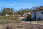 Die letzten Reste der Bremsbahn der Eiserfelder Steinwerke AG des Basaltbruches Mahlscheid (Mahlscheiderkopf). Die ehemalige Verladestation am 24.03.2011 (im gleichen Jahr angerissen) bei der alten Ziegelei in Herdorf.

Der ehemalige Steinbruch Mahlscheid (heute NSG) befindet sich im Westerwald an der Landesgrenze der Bundesländer Rheinland-Pfalz und Nordrhein-Westfalen im Bereich der Gemeinden Herdorf (Landkreis Altenkirchen) und Struthütten (Landkreis Siegen-Wittgenstein). Mitten durch den ehem. Steinbruch verläuft die Landesgrenze, so wurde der Bruch von zwei Firmen betrieben, zum einen auf der Herdorferseite (zu RLP) von der Firma Klein und zum anderen auf der Struthüttenerseite (zu NRW) von den Eiserfelder Steinwerke AG. Von beiden Brüchen führten Bremsbahnen hinab ist Tal. Die der Eiserfelder Steinwerke AG, war ca. 1,5 km lang und führte entlang der Landesgrenze nach hier hinab zur alten Ziegelei, wo das Gestein (Schotter) auf normalspurige Bahnwagen umgeladen wurde. Dafür führte vom Bahnhof Herdorf ein Anschlussgleis hinauf. 

Was ist eine Bremsbahn:
Eine Bremsbahn ist im Grunde eine Standseilbahn, aber ein sehr energiesparendes Konzept, zwei Wagen sind über ein Drahtseil verbunden, welches über eine Bremshaspel führt und kontrolliert abgebremst wird. Das zu fördernde Material wird mittels eines gebremsten Wagens hinabbefördert und der beladene schwererer Wagen zeiht somit den leeren Wagen wieder hinauf. Das Gewicht der zu Tal laufenden beladenen Wagen brachte einfach die dafür nötige Energie auf - also ein sehr energiesparendes Konzept.

Ob die Bremsbahn zwei parallel verlaufende Schienenstränge oder eine abtsche Weiche hatte, ist mir z.Z. nicht bekannt.
