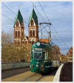 Der Partywagen 121 der Freiburger Verkehrs AG (VAG) überquert die Stühlingerbrücke (Freiburg im Breisgau) am 07.12.2013, im Hintergund die Herz-Jesu-Kirche.