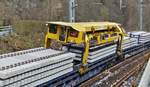 Schwellentransportschlitten 1, legt die ausgebauten Schwellen in der Mitte des Zuges ab, f�hrt einen Stapel vor und nimmt neue Schwellen mit nach vorne.