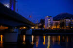 Salzburg by Night und Vollmond: Blick am 13 Januar 2025 von Station Salzburg M�lln-Altstadt in Richtung Hauptbahnhof, links die Eisenbahnbr�cke �ber die Salzach (der Bahnstrecke Salzburg - Rosenheim - �BB 300), rechts im Hintergrund der 1.287 m hohe Gaisberg.