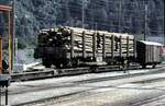 SBB Normalspur Rungenwagen 4-achsig mit Holz beladen auf RhB Rollbühne in Thusis im Oktober 1991.