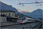 Noch liegt das weite Tal im Schatten, doch schon erhaschen die hohen Berggipfel erste Sonnenstrahlen, als in Domodossola ein SBB ETR 610 (RABDe 503) als EC 35 mit dem Ziel Milano zur Abfahrt breit